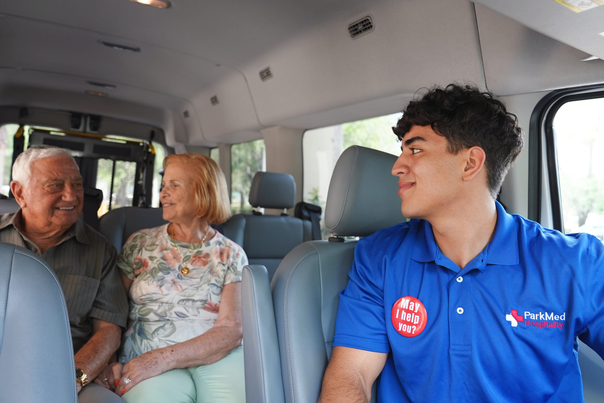 ParkMed Hospitality Employee Patient Shuttle Driver interacting with older male and female patients inside of a transit van